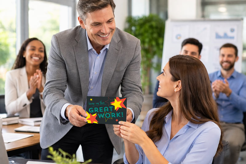 Manager recognizing an employee with a handwritten greeting card.