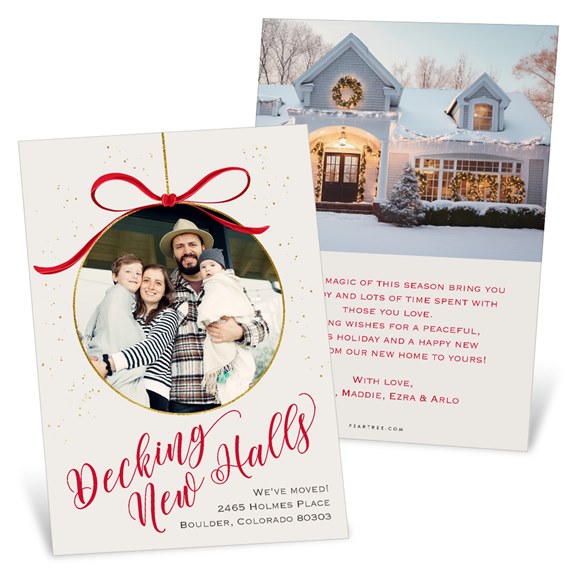 holiday moving announcement photo card with family photo in ornament frame, red bow and gold accents; back displays a decorated snowy house