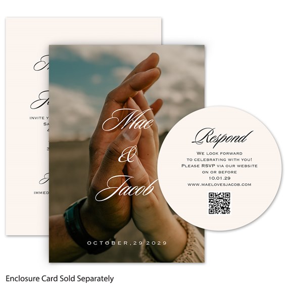 Wedding invitation with a photo of two hands touching, script names overlaid on the photo, printed date at bottom, and a round RSVP card with QR code on cream card.