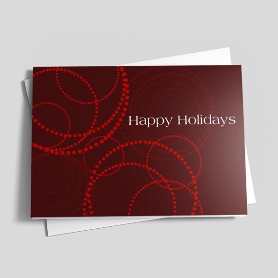 Folded burgundy holiday card with red dotted circles and white "Happy Holidays" text
