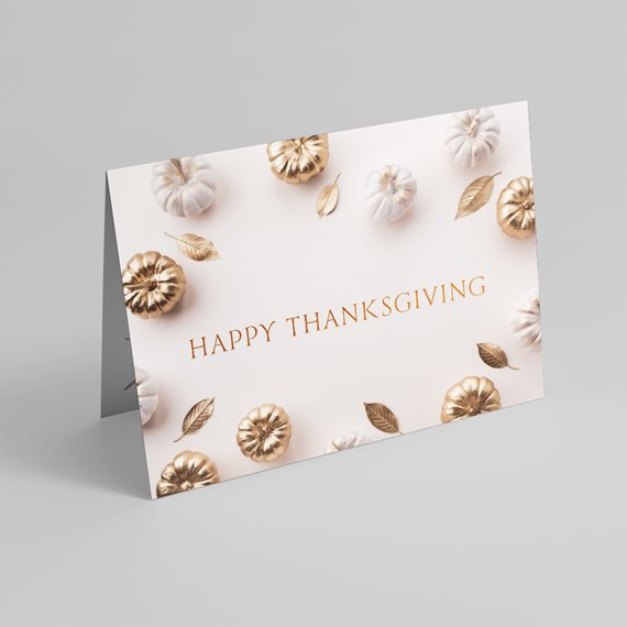 Folded Thanksgiving greeting card with white and gold pumpkins and gold leaves and centered 
