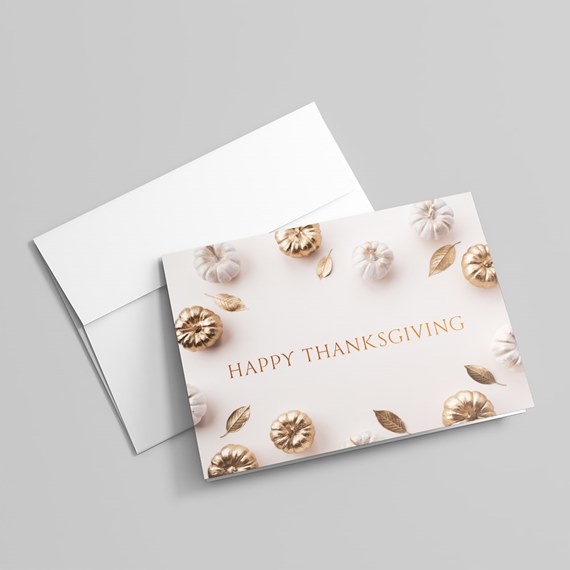 Thanksgiving greeting card with gold pumpkins and leaves on cream background and matching white envelope