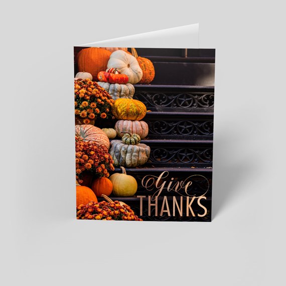 Folded Thanksgiving greeting card featuring pumpkins and mums on dark decorative stairs with "Give Thanks" text