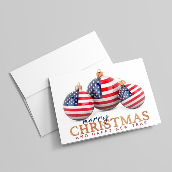 Folded holiday greeting card and envelope featuring three American-flag patterned Christmas baubles and 'Merry Christmas and Happy New Year' text