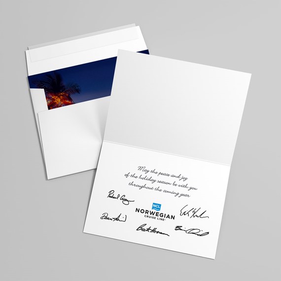 white folded holiday greeting card and envelope with navy palm postcard insert, interior printed message, signatures and small blue logo