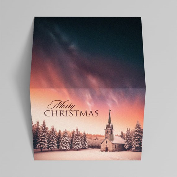 Christmas greeting card with snowy church, pine trees and colorful twilight sky reading 'Merry Christmas'.