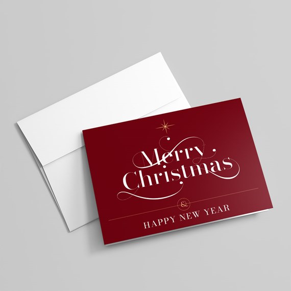 Burgundy folded Christmas card with white 'Merry Christmas' script, gold star detail and 'Happy New Year' text next to a white envelope