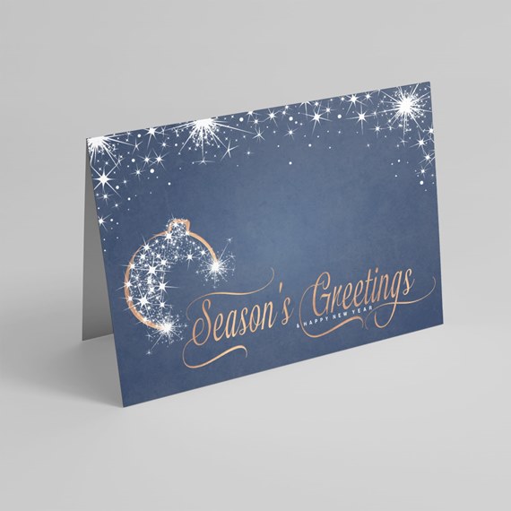Folded navy holiday card with white star sparkles, ornament design and gold calligraphy seasonal message