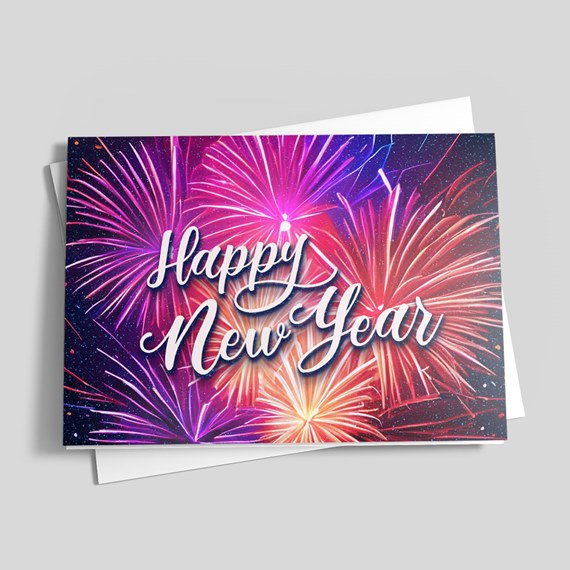 Folded greeting card with hand-lettered "Happy New Year" text over vibrant pink, purple, orange and blue fireworks; white envelope partially visible.