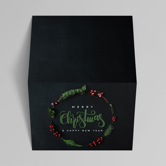 Black square gift box with green pine wreath, red berries and 'Merry Christmas & Happy New Year' text