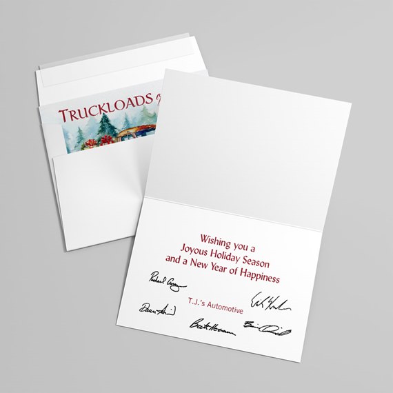 Open holiday greeting card with red printed message, black signatures and matching envelope; illustrated insert with trees and truck visible