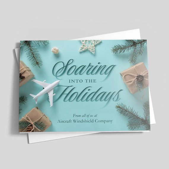 Holiday greeting card with white airplane, wrapped kraft gifts and pine branches on a teal background