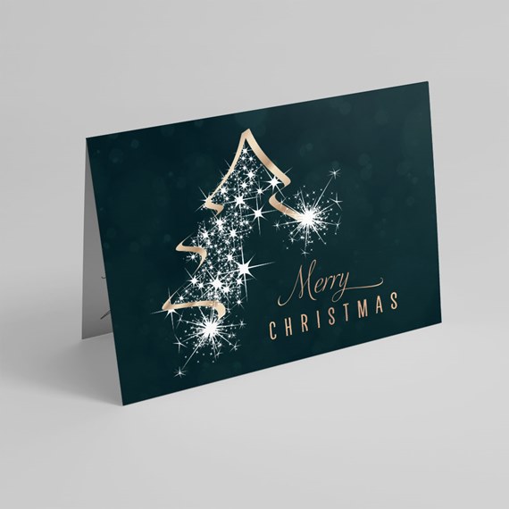 Folded Christmas card with white sparkly star tree and gold ribbon outline on dark teal background reading 'Merry Christmas'.