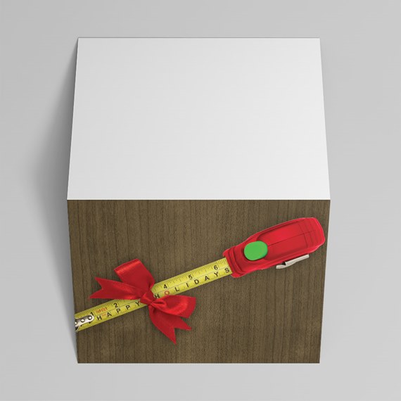 retractable measuring tape with yellow tape, red case, green button and red bow on wood