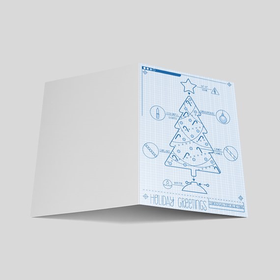 Folded holiday greeting card with blue blueprint-style Christmas tree illustration on white paper