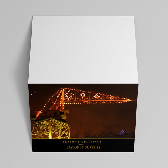Folded greeting card with nighttime photo of an industrial crane lit by orange string lights and star shapes; blank white upper panel.