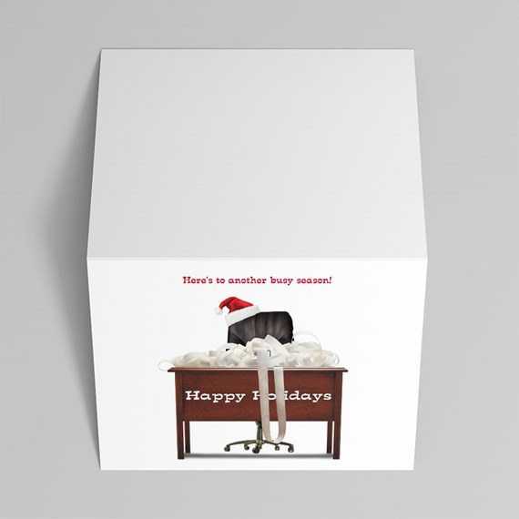 white holiday gift box with printed office scene: desk with ribbon, office chair in a Santa hat and "Happy Holidays" text