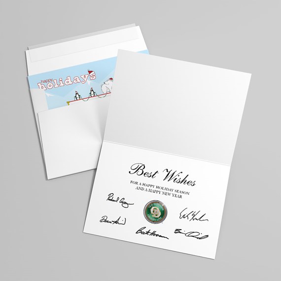 Folded white greeting card reading Best Wishes with signatures and a round seal, beside a white envelope showing a blue Happy Holidays insert with penguins.