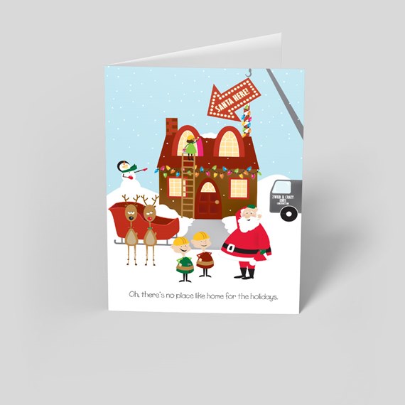 Folded holiday greeting card with cartoon Santa, elves, reindeer and sleigh in front of a decorated house and 'Santa Here' sign in a snowy scene