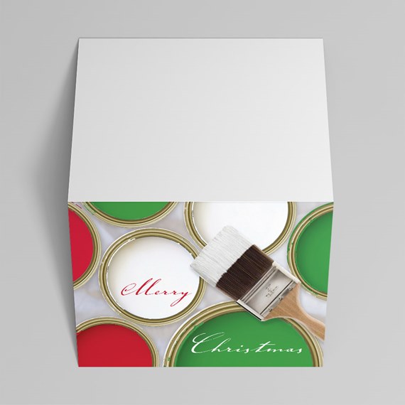 Folded Christmas greeting card showing open paint cans in red, green and white with a paintbrush and "Merry Christmas" text