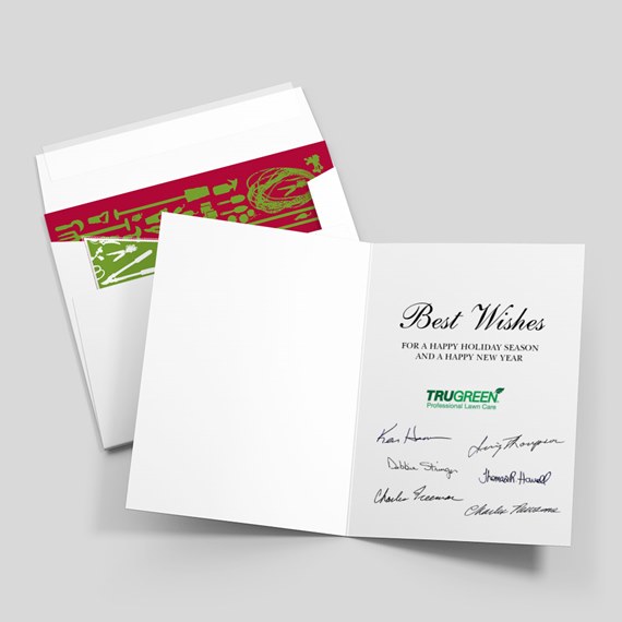 Open folded holiday greeting card with 'Best Wishes' script, signatures and green company logo, shown with envelope and red-green decorative liner