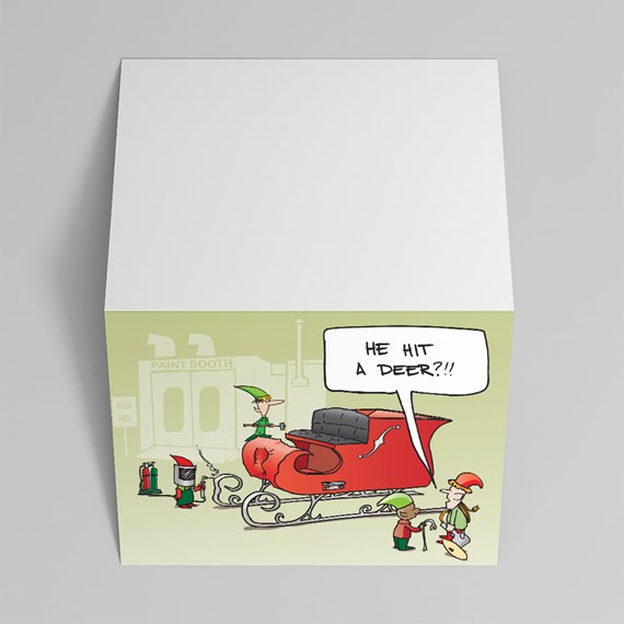 Square memo cube featuring a cartoon of elves repairing a red sleigh with the speech bubble 