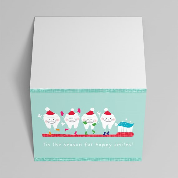 Holiday greeting card: smiling cartoon teeth in Santa hats on a red toothbrush with toothpaste on a teal background and the message 'tis the season for happy smiles!'