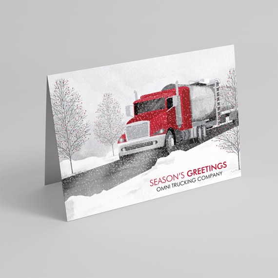 Folded holiday greeting card with red semi-truck illustration in snow and 'Season's Greetings' text
