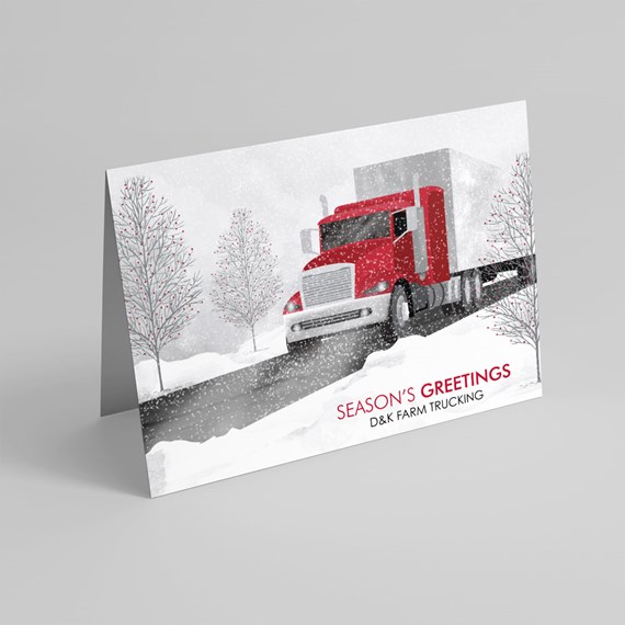 Folded holiday card showing a red semi truck on a snowy road with bare trees and falling snow and a "Season's Greetings" message.