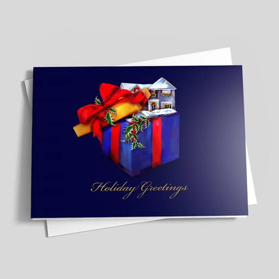 Folded navy holiday greeting card with illustrated gift box, red ribbon, snow-covered house and gold "Holiday Greetings" text.