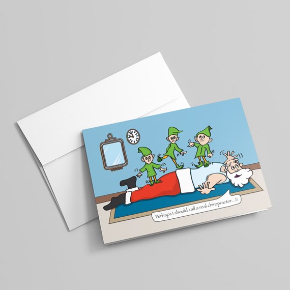 Illustrated holiday greeting card showing Santa lying face down while elves step on his back on a blue background
