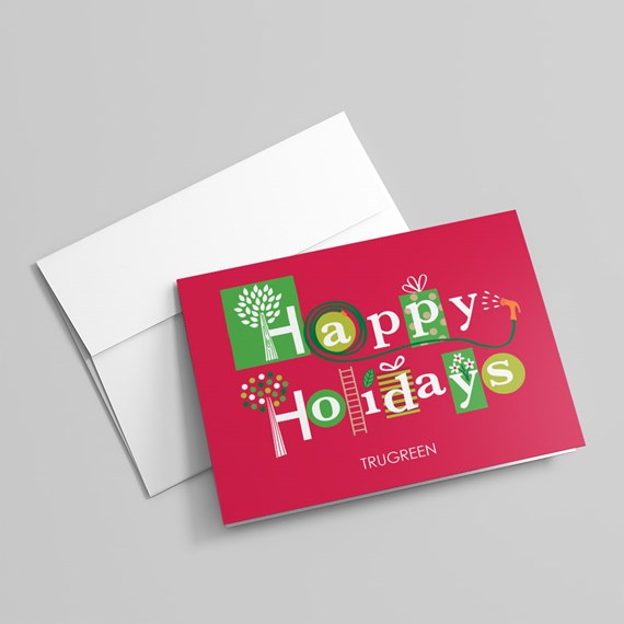 Folded red holiday greeting card with 'Happy Holidays' typography and a white envelope