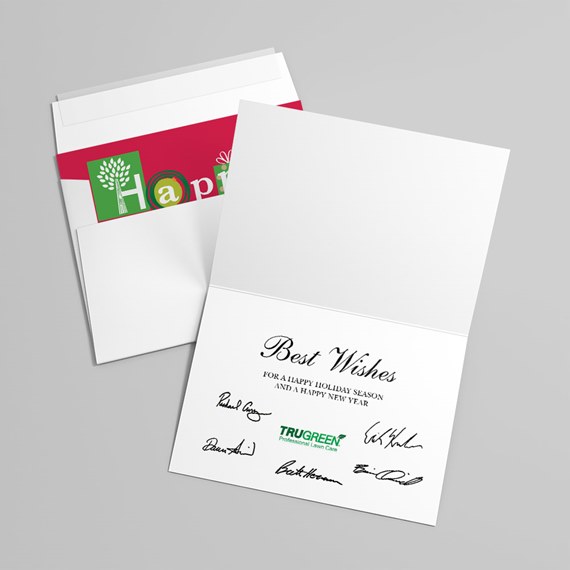 Folded white holiday greeting card with scripted greeting and printed signatures, paired with envelope with red and green festive liner