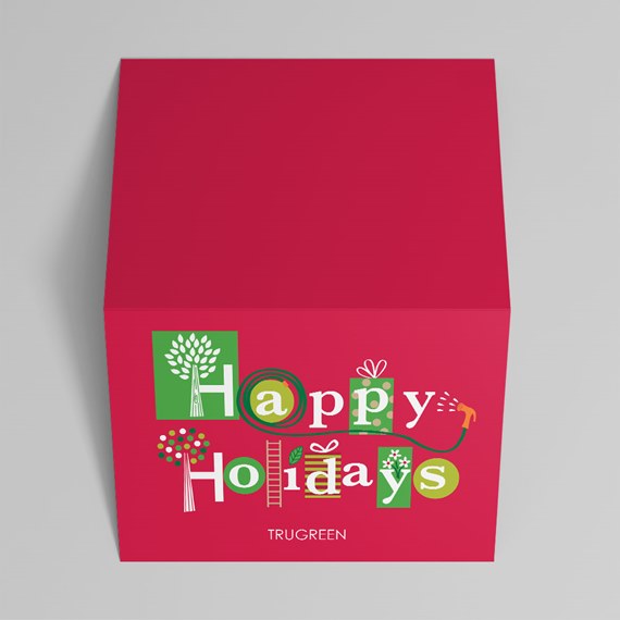 red square holiday gift box with printed "Happy Holidays" design in green and white