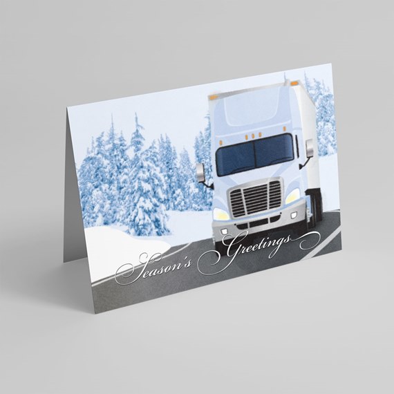 Folded holiday card showing a semi truck on a snowy road with snow-covered pine trees and "Season's Greetings" text