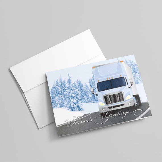 Holiday greeting card with white semi-truck on snowy road and 'Season's Greetings' text, with envelope