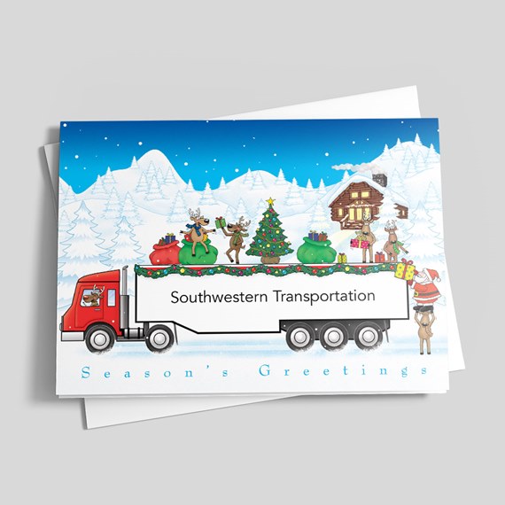 Holiday greeting card with red semi truck carrying a Christmas tree, gifts and reindeer in a snowy landscape.