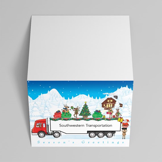 Folded holiday greeting card with red semi truck, trailer of presents, Christmas tree, reindeer and snowy cabin under a blue sky