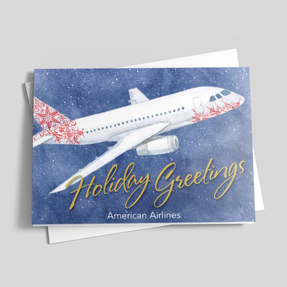 Holiday greeting card with watercolor white airplane, red decorative accents, gold "Holiday Greetings" text on a snowy blue background.