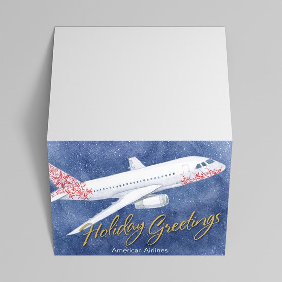 Folded holiday greeting card with white airplane illustration, red tail pattern, blue snowy background and gold script